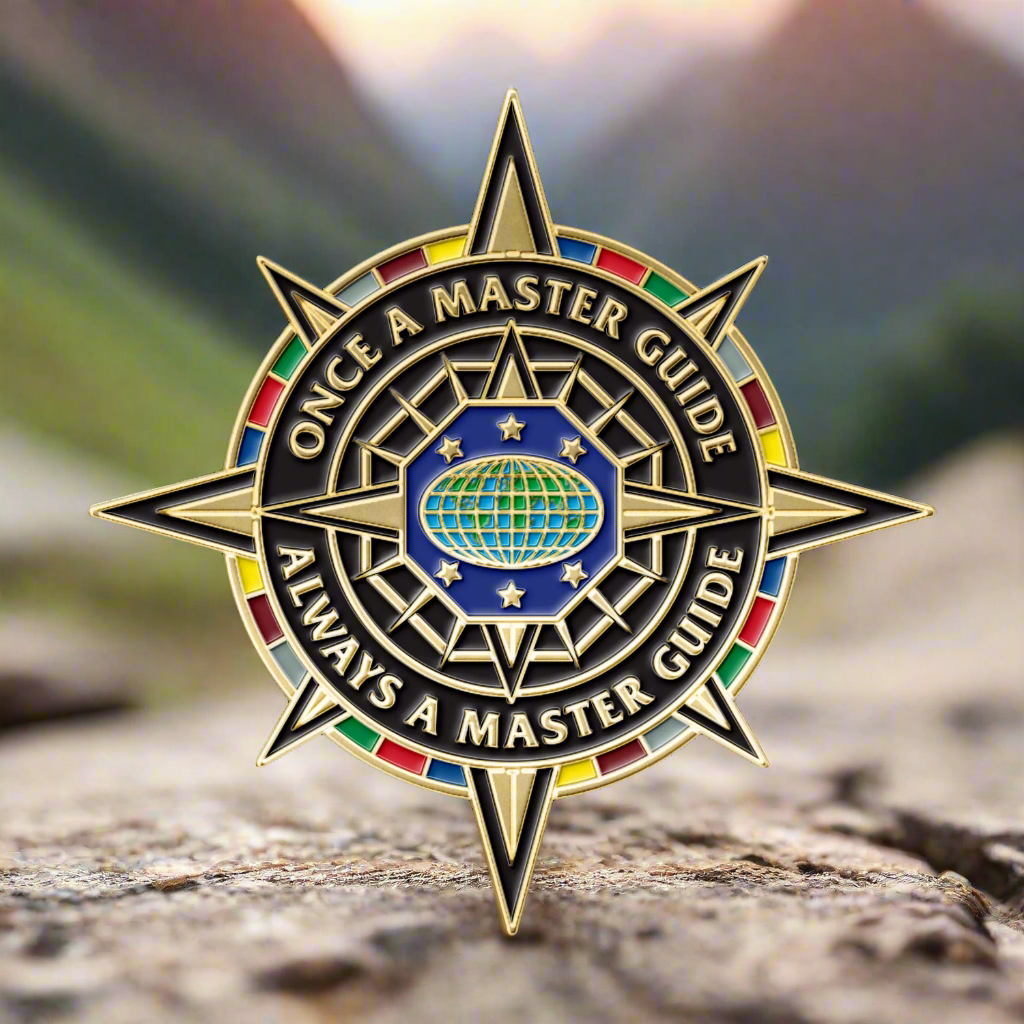 Decorative badge with star design and text 'Once a Master Guide, Always a Master Guide' on a white background